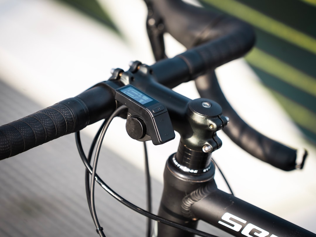 Close-up of a black bicycle handlebar with device.